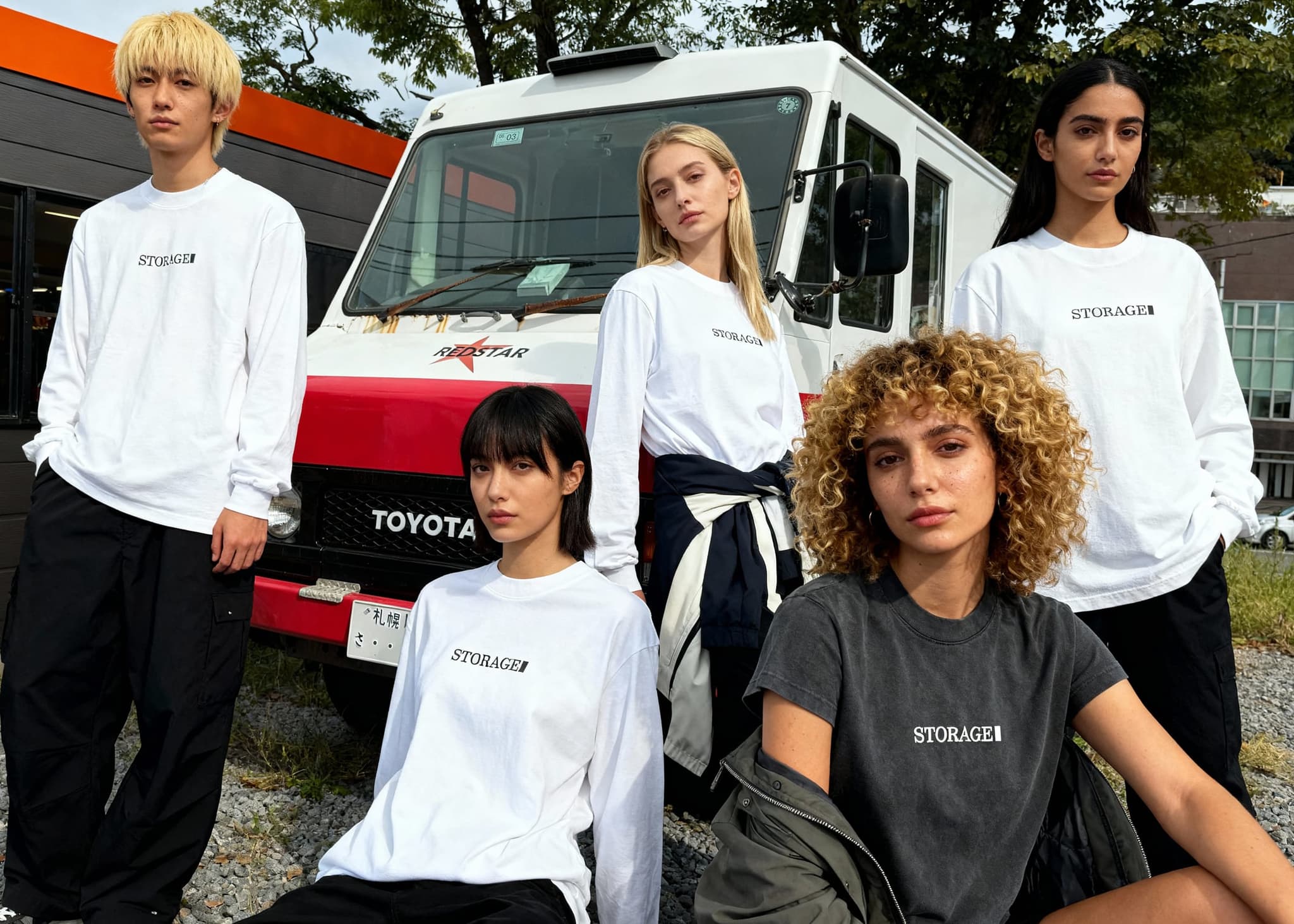 STORAGEのルックブック。ロゴ入りウェアを着た5人とRED STARの車両。